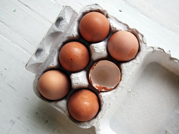 Eggs in a box with one broken egg