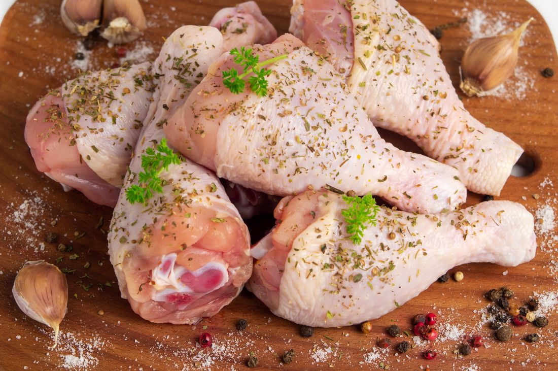 Raw chicken legs on a board 