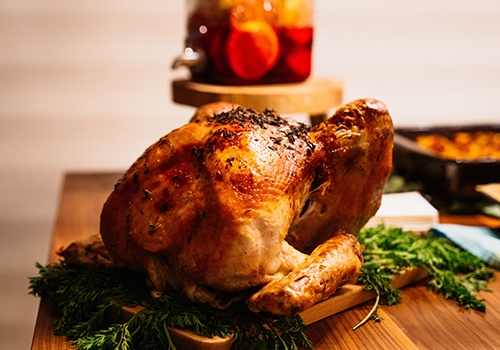 Succulent roast chicken with crispy skin on a board resting