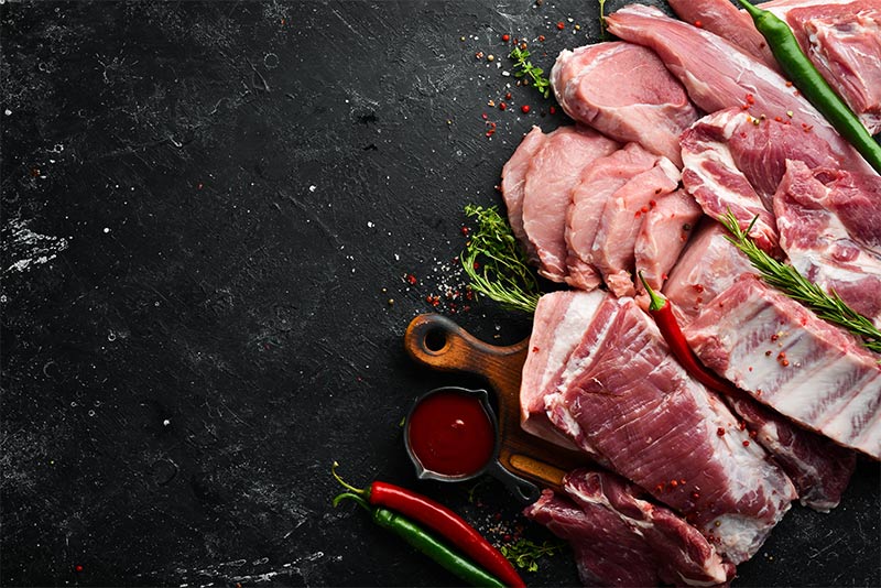 Different raw cuts of lamb arranged on a granite countertop.