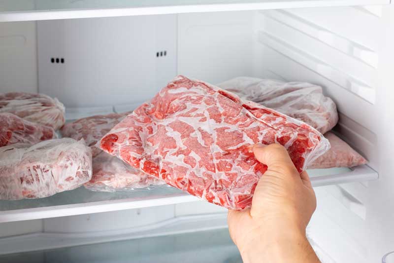 Person taking frozen pork out of the freezer