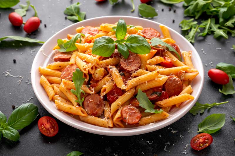 Sausages and pasta with basil.